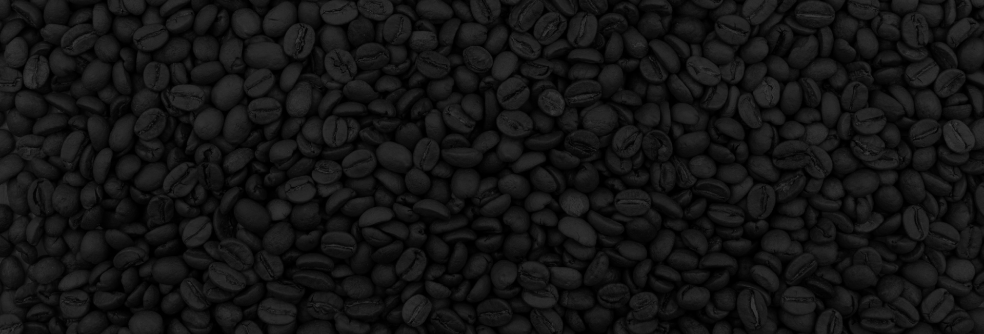 Close-up of dark coffee beans on a black background